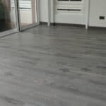 Smooth grey wood flooring installed in a modern condominium living space.