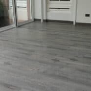 Smooth grey wood flooring installed in a modern condominium living space.