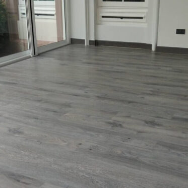 Smooth grey wood flooring installed in a modern condominium living space.