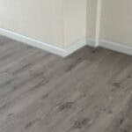 Smooth grey vinyl flooring in a modern residential interior with white baseboards.