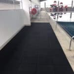Black rubber flooring tiles on balcony, ideal for poolside and outdoor spaces.