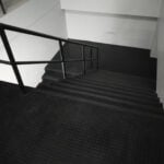 Eco-friendly black rubber flooring for stairs and lobby areas.