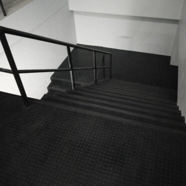 Eco-friendly black rubber flooring for stairs and lobby areas.