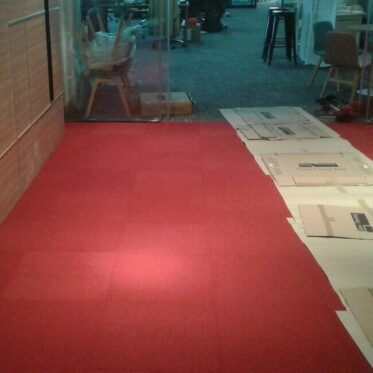 Red vinyl flooring installation in office space.