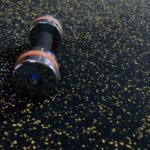 High-quality speckled flooring with a portable vacuum cleaner on surface, suitable for condos and office spaces.