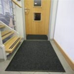 Non-slip black entrance mat for office or condo doorways, enhancing safety and cleanliness.