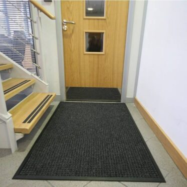 Non-slip black entrance mat for office or condo doorways, enhancing safety and cleanliness.