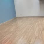 Smooth light wood flooring installed in a modern bedroom or living space.