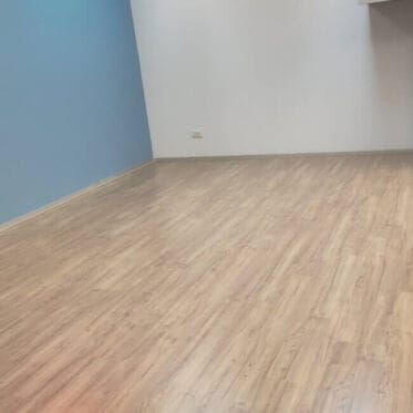 Smooth light wood flooring installed in a modern bedroom or living space.