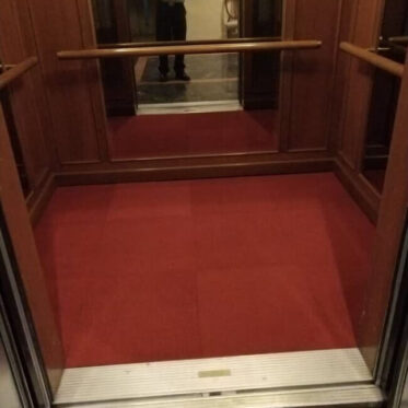 Red carpet flooring inside elevator for residential and commercial buildings.