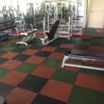 Colourful interlocking rubber floor tiles in a gym setting.