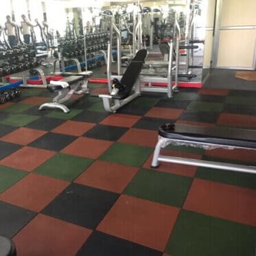 Colourful interlocking rubber floor tiles in a gym setting.