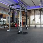Gym fitness equipment inside a modern exercise room with large windows and natural lighting.