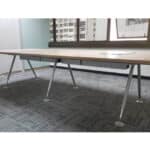 Smooth wooden office desk with metal legs in a modern workspace.