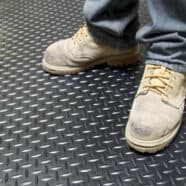 Heavy-duty black rubber flooring with diamond plate texture for industrial or commercial use.