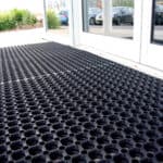 Black interlocking floor mat, durable and easy to install for indoor and outdoor spaces.