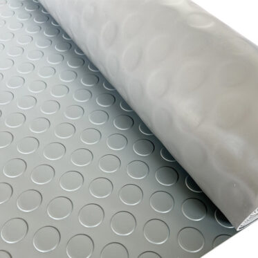 Flexible rubber flooring with circular patterns for residential and commercial use.