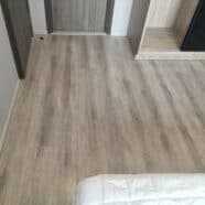 Natural wood grain flooring in modern condo bedroom and living space.
