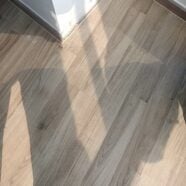 Natural wood grain flooring with sunlight reflection, ideal for condo and office interiors.