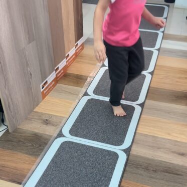Flexible anti-slip flooring tiles demonstration in a showroom artificial flooring product display for homes and offices.