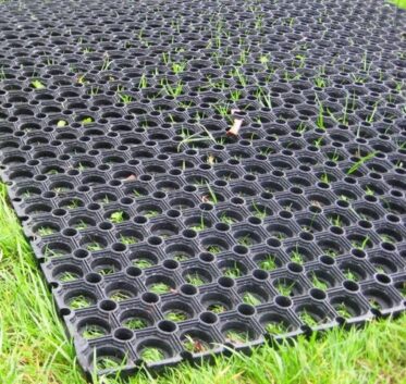 Interlocking rubber grass seed mat for ground stabilization and decorative landscaping.